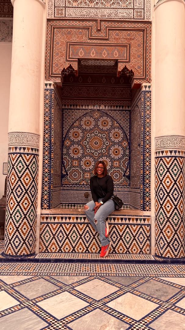 MaryAnne Iwara seated in front of ornate mosaic tiles